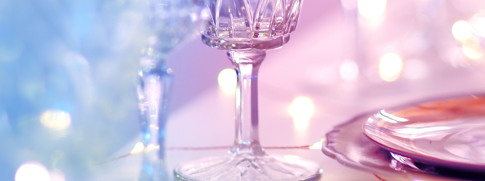 A blue and pink image of sparkling glassware.